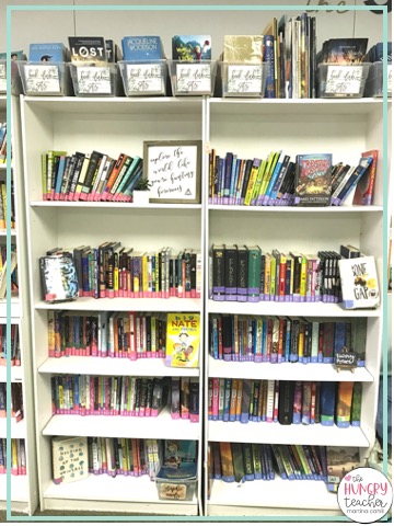 BOOK CLUBS SETS OF BOOK IN BINS ON TOP OF SHELVES IN MIDDLE SCHOOL CLASSROOM M